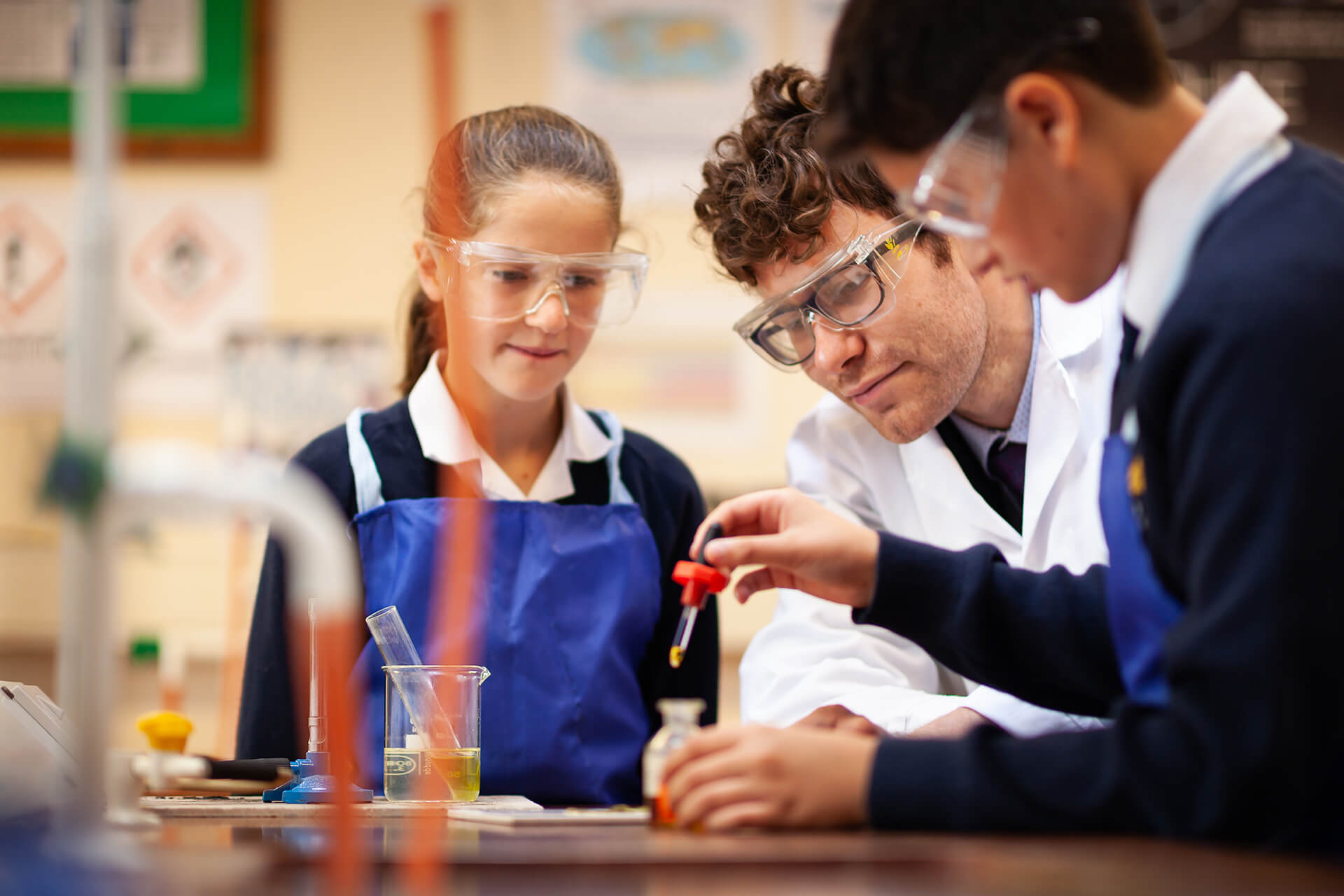 Boy and girl with science teacher