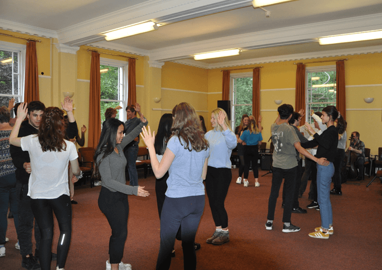 Mixed pupils dancing in room at Quaker retreat