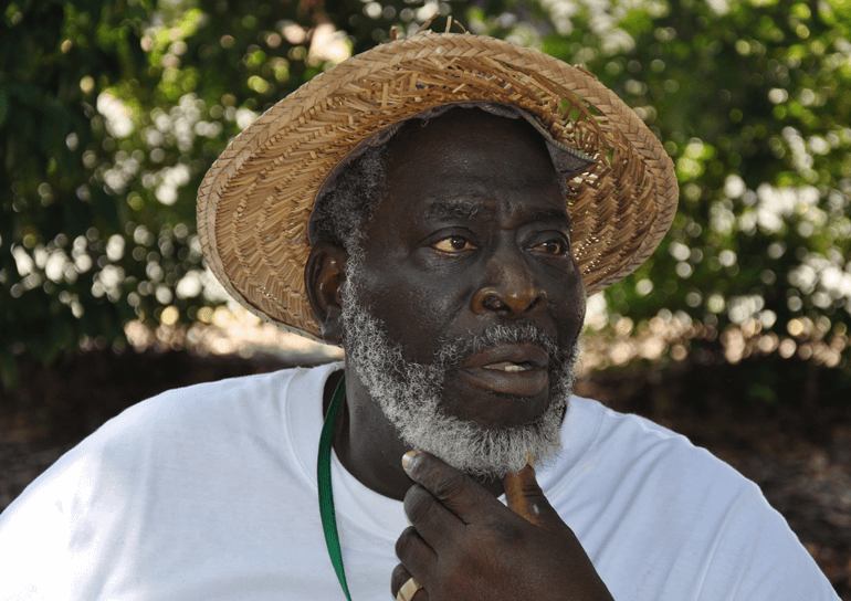 Black man in straw hat and white t-shirt