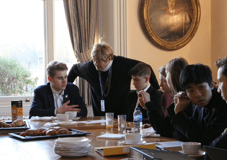Leighton Park Sixth Formers sitting at table at workshop discussing ethics in business