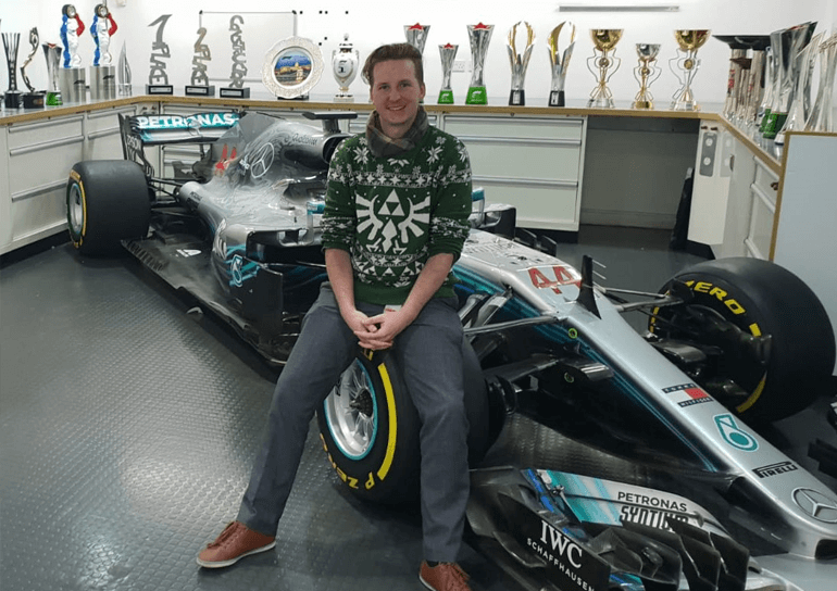 Old Leightonian, Joey MacMillan, sitting on wheel of Formula One car