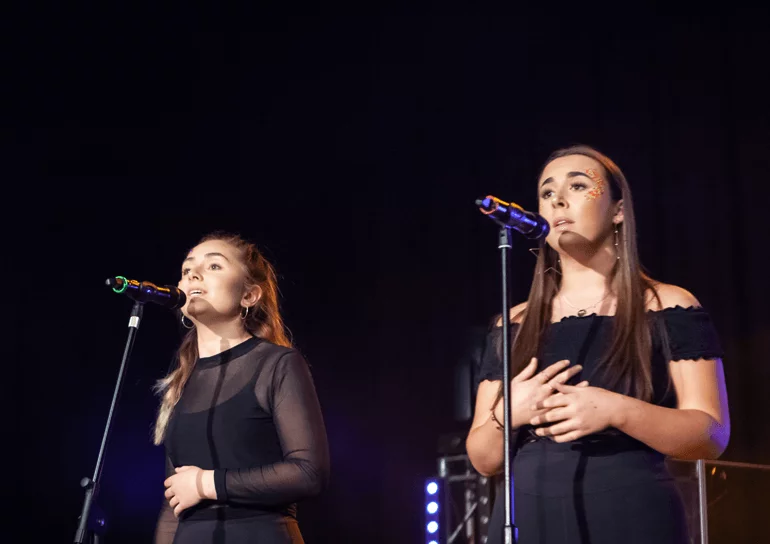 Two female Leighton Park students singing on stage