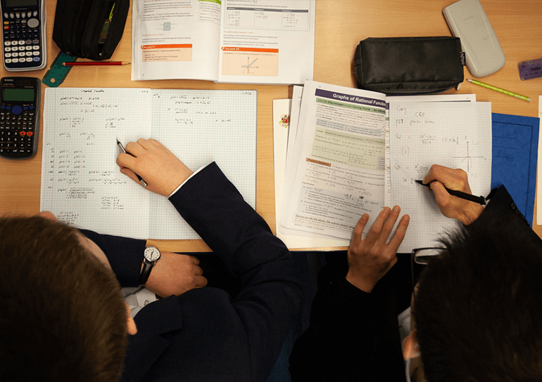 Looking down on two pupils working in their maths books