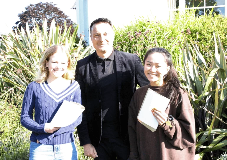Two Leighton Park pupil stand with Head, Matthew Judd with their A-Level results