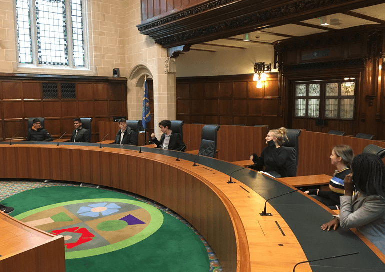 Leighton Park pupils sitting at desks in Parliament