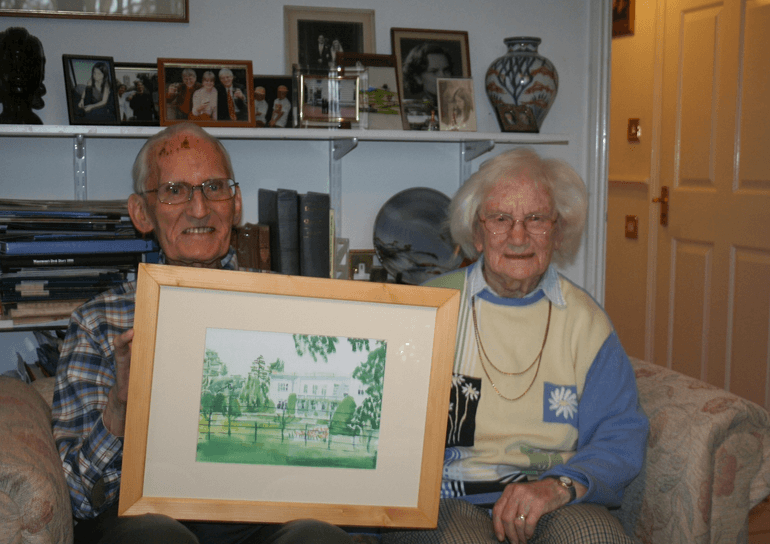 Former Head, Bill Spray with his wife Christine Spray with a water colour painting of Leighton Park building