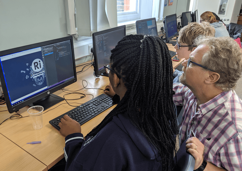 Leighton Park pupils being helped at computer by Royal Institute tutor