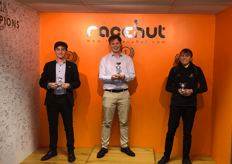 Three Leighton Park students holding trophies on the winners podium at Mini Cooper
