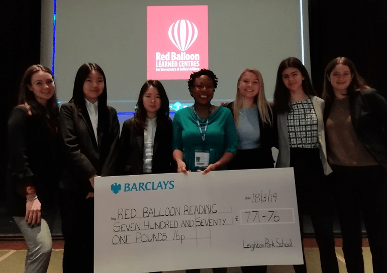 Group of students and another lady holding a giant cheque for £771.76