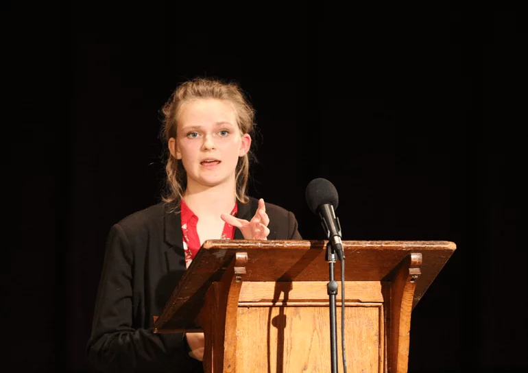 Leighton Park girl giving a speech at a wooden alter