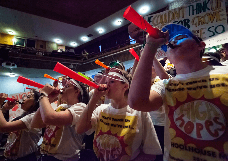 Leighton Park students blowing on plastic trumpets at house music festival