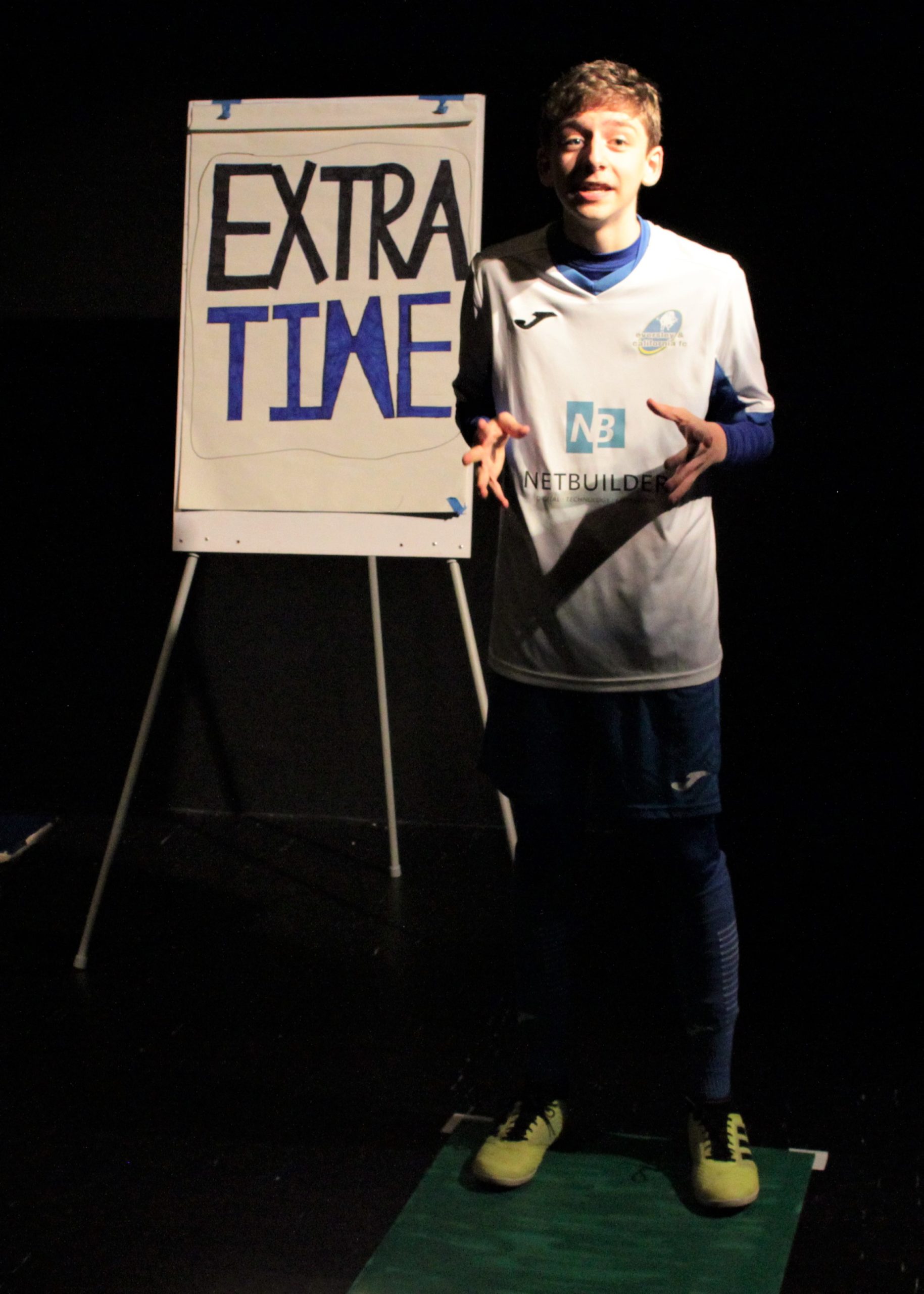 Boy stood in front of sign saying 'Extra time'
