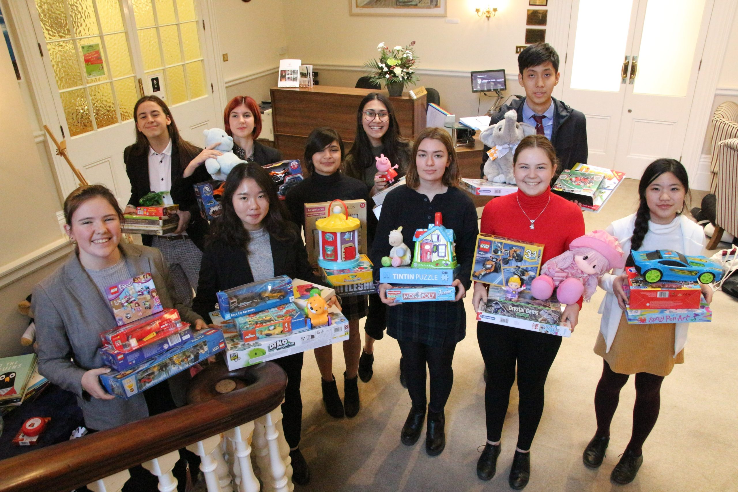 Leighton Park girls holding toys to be donated to Enrichment Amicus Reading Family Aid
