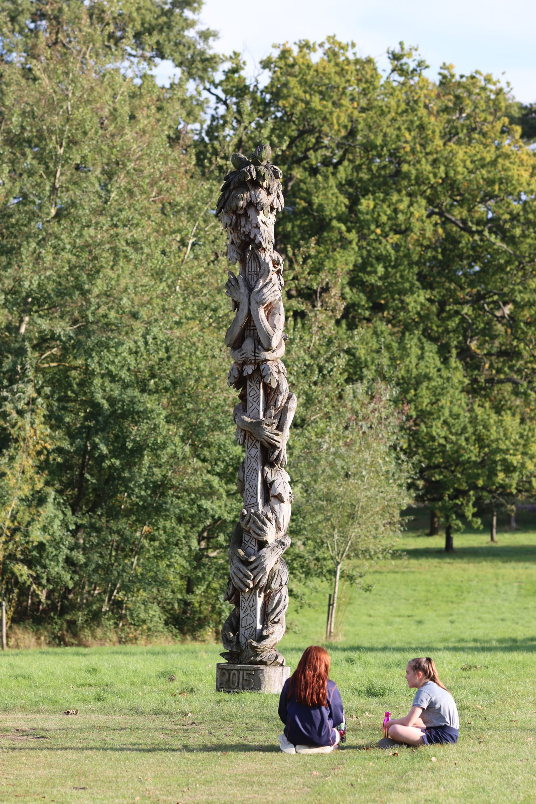 Girls sat by Leighton Parks Peace Pole