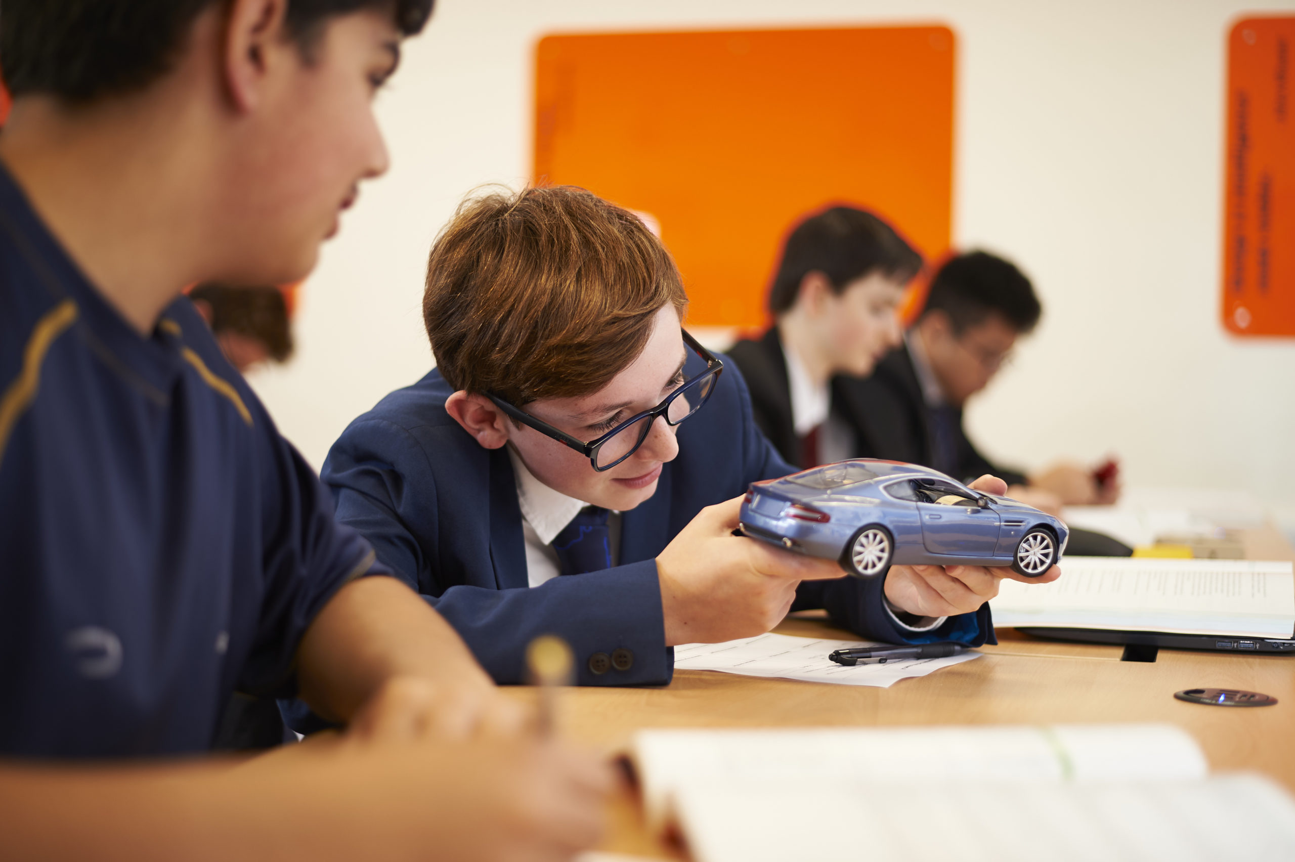 Student looking closely at model car
